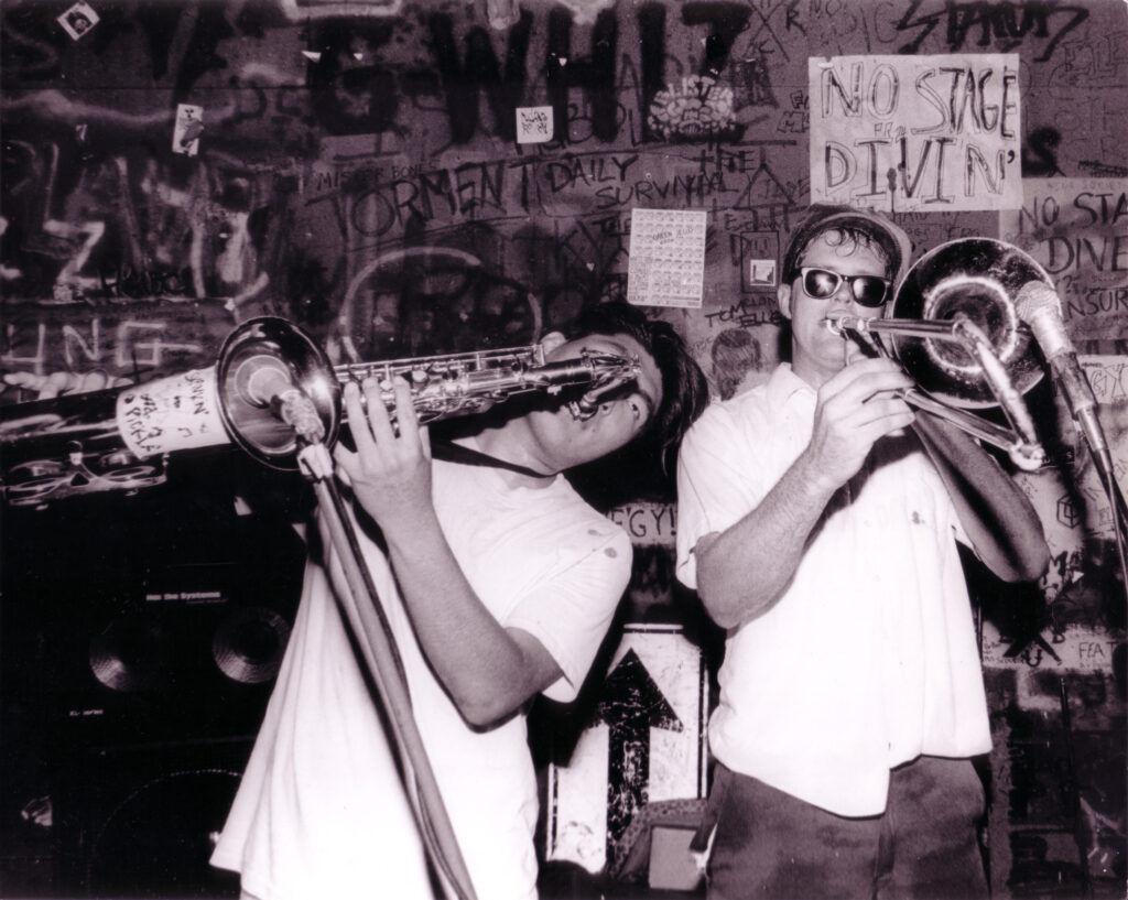Gilman st 1990 a saxophone and trombone player with graffiti behind them