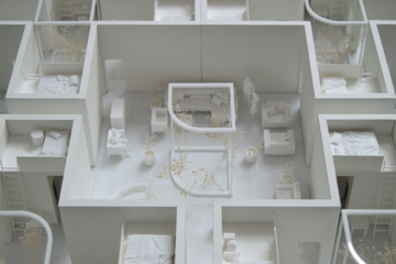 Architectural art display featuring small white housing models.