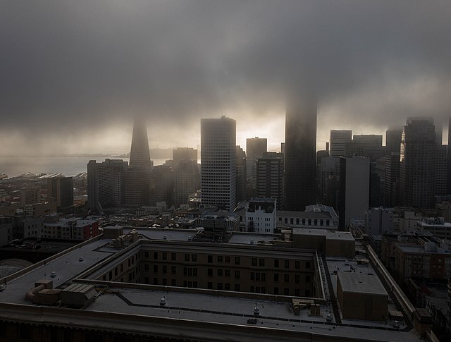 The fog-obscured skyline of downtown San Francisco viewed from a highrise hotel room.