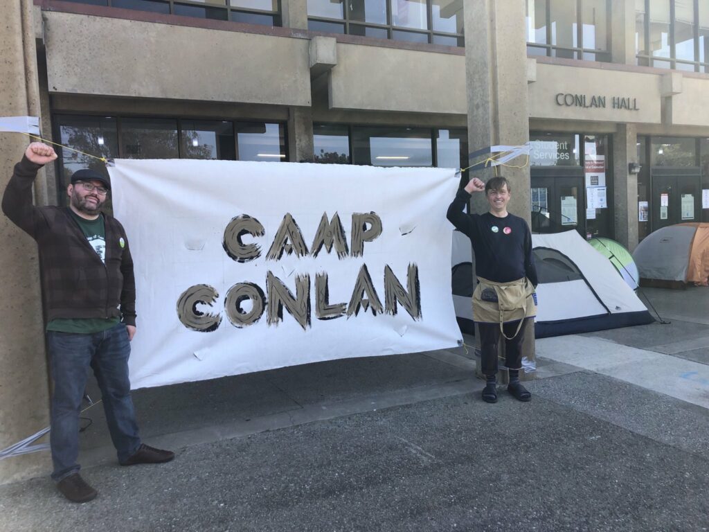 Faculty stands in front of the Camp Conlan Sign