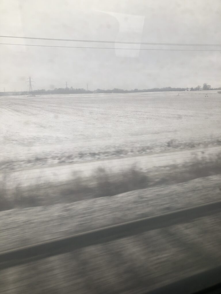 Photo of snow by the train tracks in midwest america. No buildings or trees or people. Just some tracks and snow.