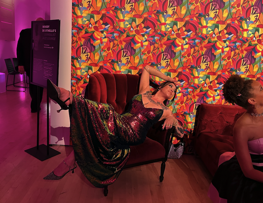 Description: The Author of the article in a rainbow sequined gown, stretched out on a sofa with the back of her palm on her forhead